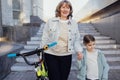 Young grandmother teaches her cute little granddaughter to ride a bicycle