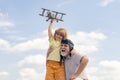 Young grandson and old grandfather playing with plane together on blue sky. Cute child with granddad playing outdoor