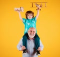 Young grandson and old grandfather with toy plane and wooden toy truck. Men generation granddad and grandchild. Elderly