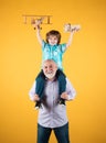 Young grandson and old grandfather with toy plane and wooden toy truck. Men generation granddad and grandchild. Elderly