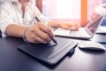 Young graphic designer man using digital tablet and computer laptop on black table at home office Royalty Free Stock Photo