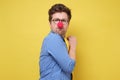 A young greedy man with red clown nose hides something in his hands and looks warily forward Royalty Free Stock Photo