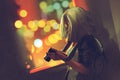 Young grey haired woman holding a camera near the window on the night city Royalty Free Stock Photo