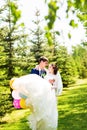 Young groom carrying his beautiful wife