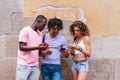 young group of friends visiting Barcelona checking their phones on the street