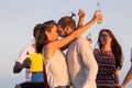 Young group having fun on the beach and dancing in a convertible car Royalty Free Stock Photo