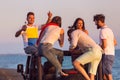 Young group having fun on the beach and dancing in a convertible car Royalty Free Stock Photo