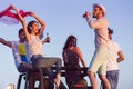 Young group having fun on the beach and dancing in a convertible car Royalty Free Stock Photo