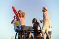 Young group having fun on the beach and dancing in a convertible car Royalty Free Stock Photo