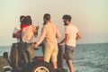 Young group having fun on the beach and dancing in a convertible car Royalty Free Stock Photo