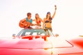 Young group having fun on beach playing guitar Royalty Free Stock Photo