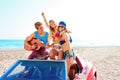 Young group having fun on beach playing guitar Royalty Free Stock Photo