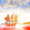 Young group having fun on beach playing guitar Royalty Free Stock Photo