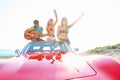 Young group having fun on beach playing guitar Royalty Free Stock Photo