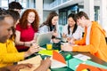 Young group of high school students studying together at cafeteria campus table Royalty Free Stock Photo