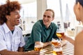 Young group of multiracial people drinking cold beer at beach bar terrace Royalty Free Stock Photo