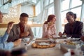 Young group of people in restaurant lunch and talks Royalty Free Stock Photo