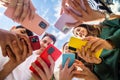 Young group of people using mobile phone device standing in circle outdoors Royalty Free Stock Photo