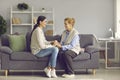 Young grown daughter and old senior mother holding hands sitting on home sofa Royalty Free Stock Photo