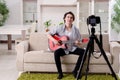 Young guitar player recording video for his blog