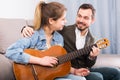 Guitar tutor helping client learn instrument