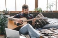 Young guitarist hipster at home with guitar in bedroom playing serious Royalty Free Stock Photo