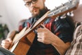 Young guitarist hipster at home with guitar fix capo Royalty Free Stock Photo