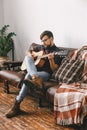 Young guitarist hipster at home with guitar sitting playing relaxed Royalty Free Stock Photo