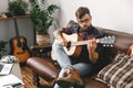 Young guitarist hipster at home playing guitar concentrated Royalty Free Stock Photo