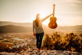 Young guitarist holding an acoustic guitar and looking to sunset.Finding inspiration.Sucessful music creator.New upcoming artist Royalty Free Stock Photo
