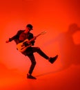 A young guitarist plays the electric guitar and jumps on a red light Royalty Free Stock Photo