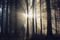 Young guy with a backpack standing in a forest in the mist at sunrise Royalty Free Stock Photo