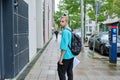 Young guy with backpack walking along street of modern city Royalty Free Stock Photo