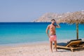 young guy on the beach of Mykonos, Elia beach Mikonos, Mykonos beach during summer with umbrella and luxury beach chairs Royalty Free Stock Photo
