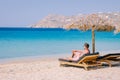 young guy on the beach of Mykonos, Elia beach Mikonos, Mykonos beach during summer with umbrella and luxury beach chairs Royalty Free Stock Photo