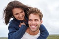 Young guy with a big smile piggybacking his girlfriend