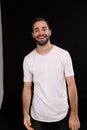 Cheerful guy in a white T-shirt on a black background Royalty Free Stock Photo