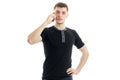 A young guy in a black t-shirt is calling on a cell phone Royalty Free Stock Photo