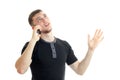 A young guy in a black t-shirt looks up and speaks on a mobile phone Royalty Free Stock Photo