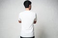 Young guy in blank white t-shirt, back side, horizontal studio p