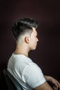 Young guy brunette with pompadour volume haircut 50s - 60s. real photo retro hair style for barbershop, side Royalty Free Stock Photo