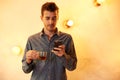 Young guy with cellphone and tea Royalty Free Stock Photo