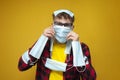 young guy in closed medical masks, a lot of covid masks on the guy\'s face and head, pandemic stress