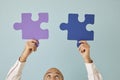 Man holding and connecting purple and blue jigsaw puzzle pieces that match perfectly Royalty Free Stock Photo