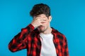 Young guy covers his face with hands from fatal disappointment, failure. Royalty Free Stock Photo