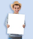 A young guy in a cowboy hat holds an announcement Royalty Free Stock Photo