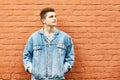 Young guy in a denim jacket against a brick wall. copyspace Royalty Free Stock Photo