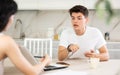 Young guy discussing deal with saleswoman in kitchen