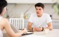 Young guy discussing deal with saleswoman in kitchen