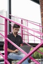 Young guy entrepreneur working outside using modern laptop sitting on stairs. Concept of successful people startup. Royalty Free Stock Photo